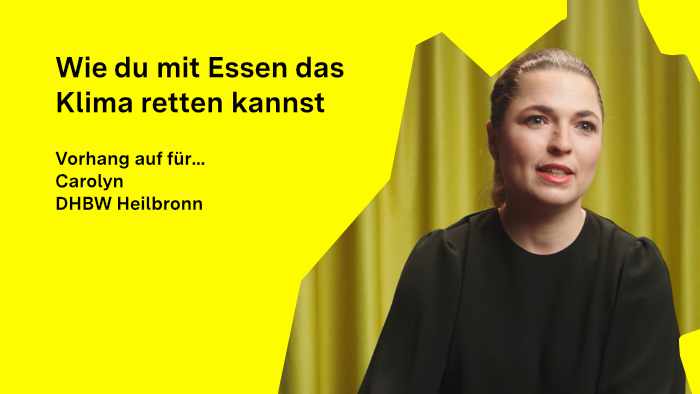 Carolyn Hutter schaut in die Kamera, im Hintergrund ist ein Vorhang zu sehen.