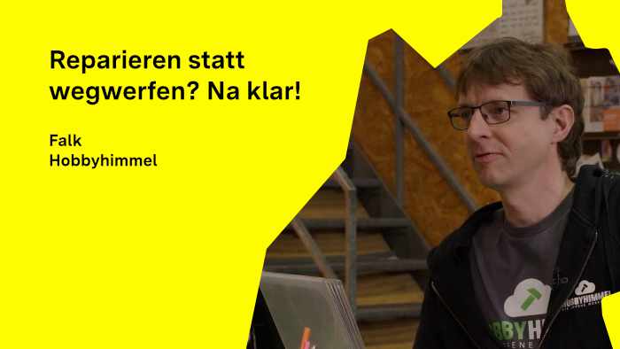 Falk Hatope, Teammitglied im Hobbyhimmel, steht in der Reparaturwerkstatt, blickt zur Seite und antwortet auf Interviewfragen.