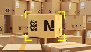 Viele Versandpakete sind übereinandergestapelt. In der Mitte steht ein Paket mit dem Logo der Nachhaltigkeitsstrategie Baden-Württemberg.