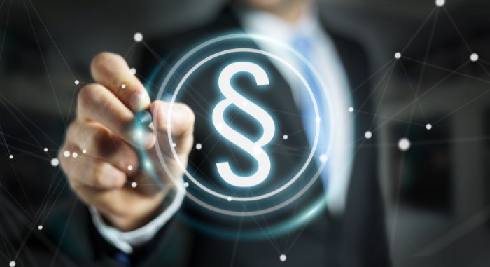 Eine Hand zeichnet einen Paragrafen mit einem 3D Stift.