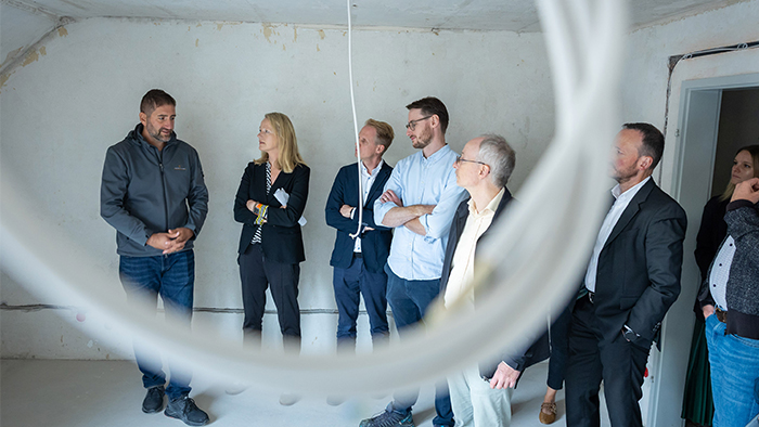 Menschen stehen in einem Haus, das saniert wird und schauen sich die Baustelle an.